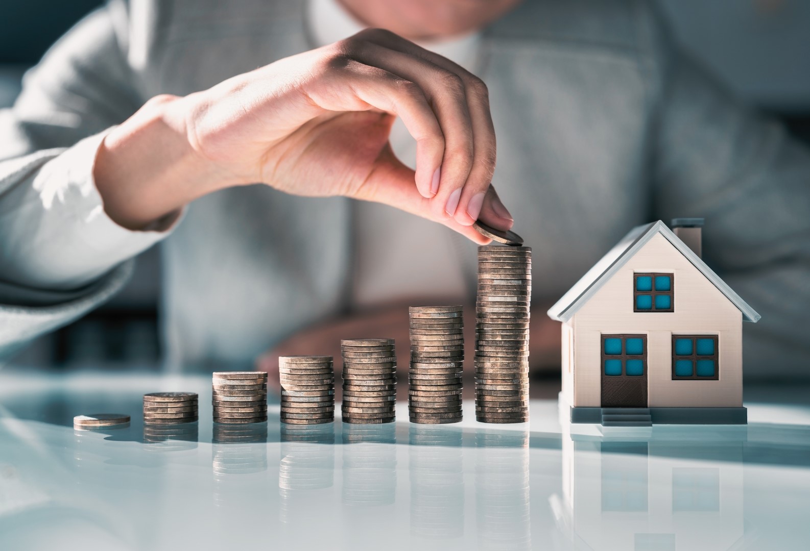 Mit Münzen dargestellte Wertsteigerung von Immobilien